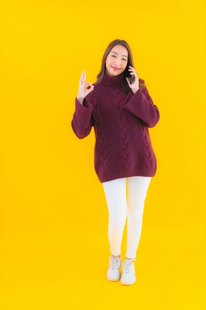 세로 아름 다운 젊은 아시아 여자 스마트 휴대 전화를 사용