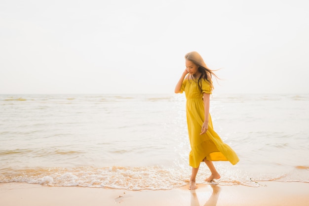 肖像画美しい若いアジア女性笑顔とビーチと海の海の上を歩くリラックス