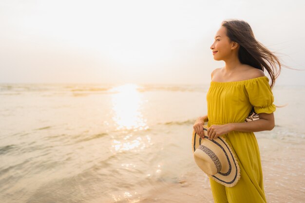 肖像画美しい若いアジア女性笑顔とビーチと海の海の上を歩くリラックス