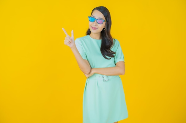 세로 아름다운 젊은 아시아 여자는 색상 배경에 3d 안경을 착용