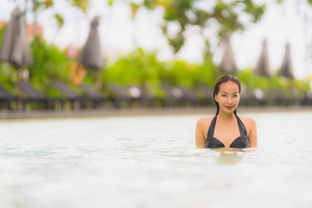 Бикини носки женщины портрета красивое молодое азиатское вокруг бассейна в курорте гостиницы почти море пляжа океана