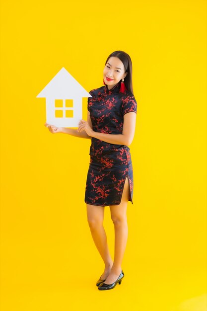 Portrait beautiful young asian woman wear chinese dress show home sign