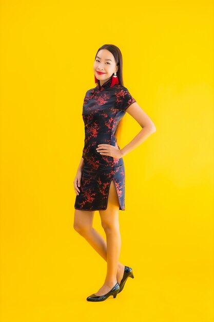 肖像画の美しい若いアジアの女性はアクションでチャイナドレスを着る