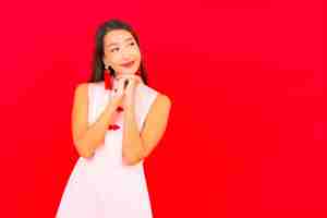 Free photo portrait beautiful young asian woman wear chinese new year clothing on red wall