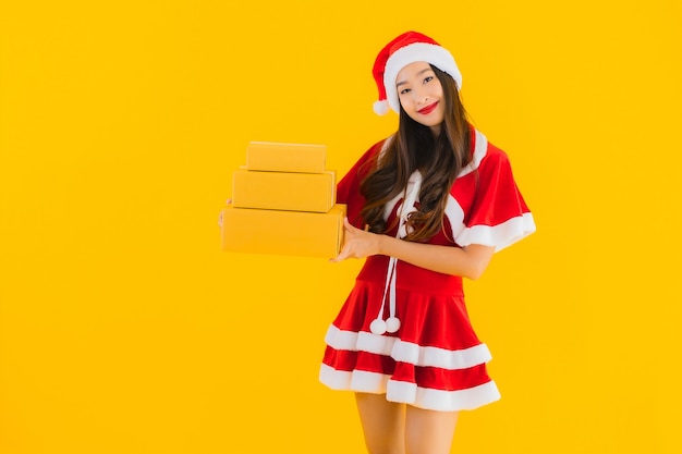 肖像画美しい若いアジアの女性は小包ボックスとクリスマスの服の帽子を着用します