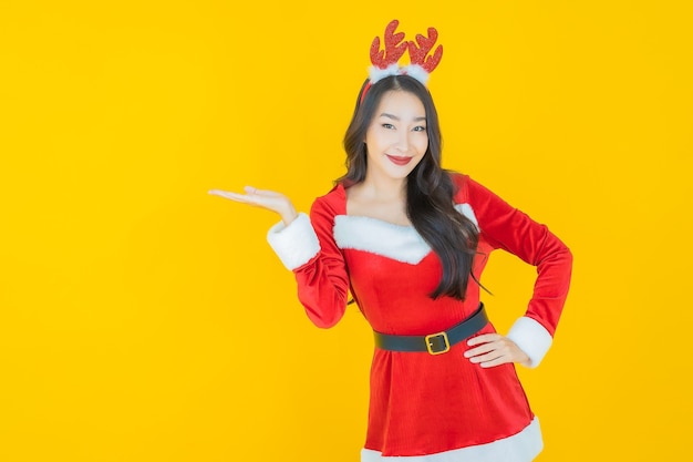 肖像画美しい若いアジアの女性は黄色のアクションでクリスマスの衣装を着ます