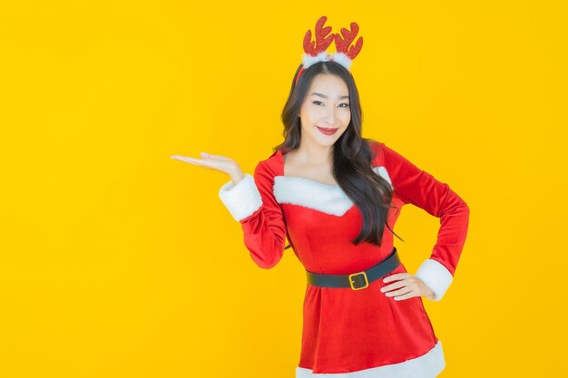 肖像画美しい若いアジアの女性は黄色のアクションでクリスマスの衣装を着ます