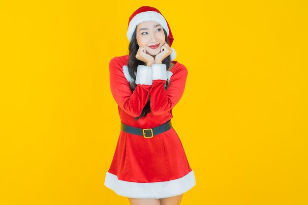 肖像画美しい若いアジアの女性は黄色のアクションでクリスマスの衣装を着ます