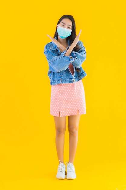 肖像画の美しい若いアジアの女性は、コロナウイルスやcovid19を保護するためのマスクを着用