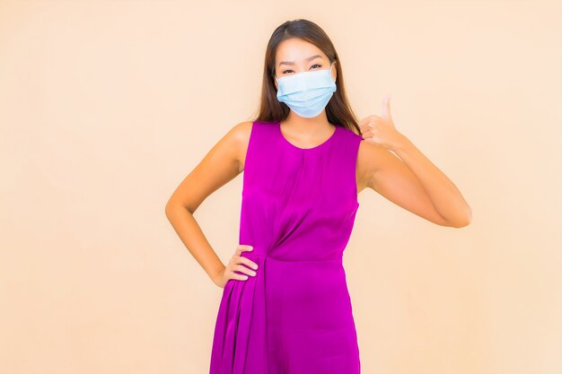 세로 아름 다운 젊은 아시아 여자 착용 마스크 색상 배경에 covid19 또는 코로나 바이러스로부터 보호