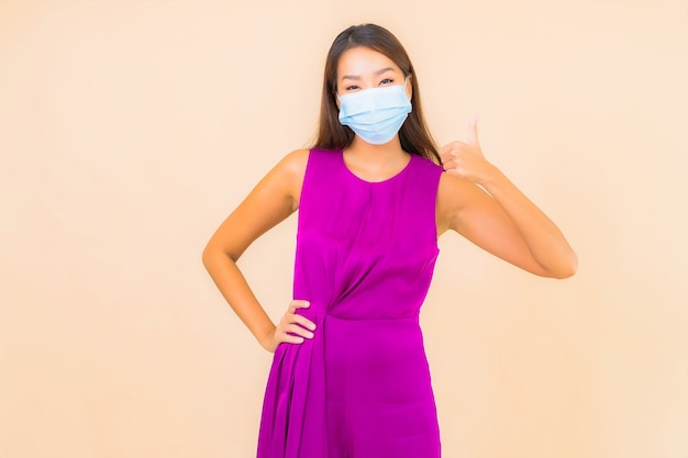 Portrait beautiful young asian woman wear mask for protect from covid19 or corona virus on color background