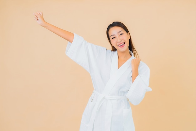 Portrait beautiful young asian woman wearing bathrobe with smile on beige