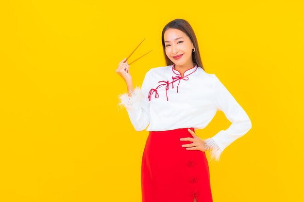 노란색에 먹을 준비가 젓가락으로 초상화 아름 다운 젊은 아시아 여자
