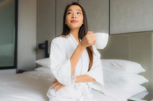침실에서 커피 컵 초상화 아름 다운 젊은 아시아 여자