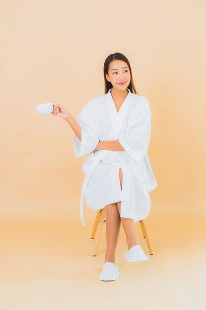 Portrait beautiful young asian woman with coffee cup on beige