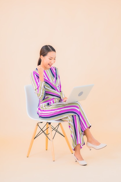 Portrait beautiful young asian woman with computer laptop on color