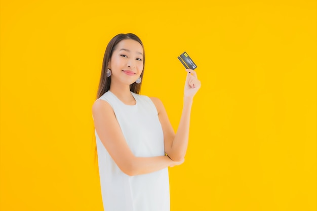 Женщина портрета красивая молодая азиатская с кредитной картой для покупок онлайн