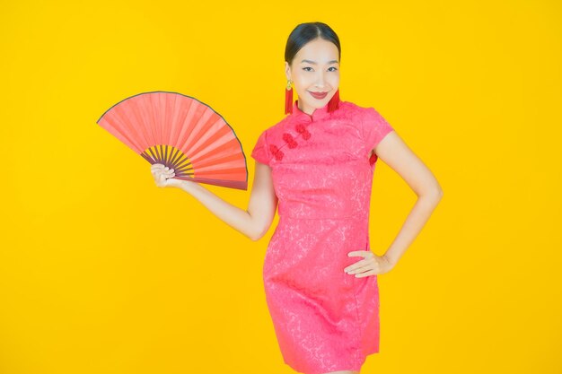 Portrait beautiful young asian woman with fan on color background