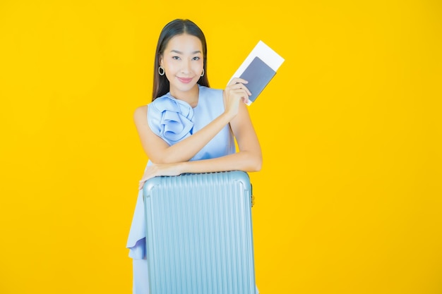 여행 준비가 된 수하물 가방과 여권을 가진 아름다운 젊은 아시아 여성 초상화