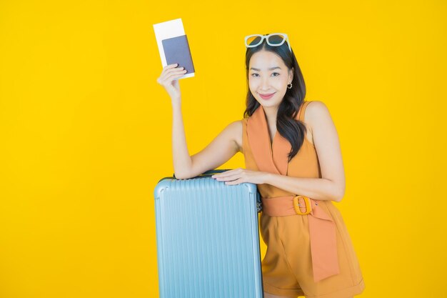 旅行の準備ができている荷物バッグとパスポートを持つ美しい若いアジアの女性の肖像画