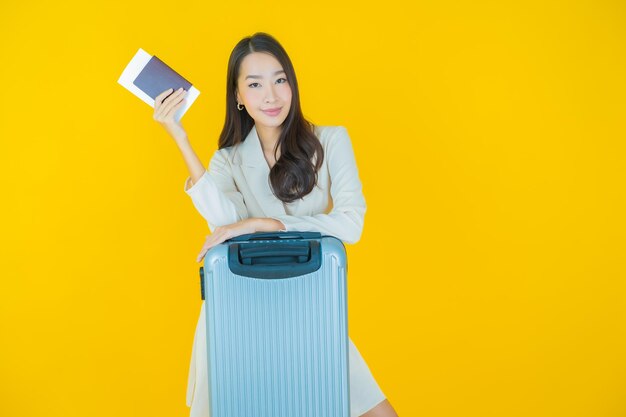 여행 준비가 된 수하물 가방과 여권을 가진 아름다운 젊은 아시아 여성의 초상화