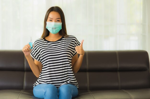 Portrait of beautiful young asian woman with mask on sofa