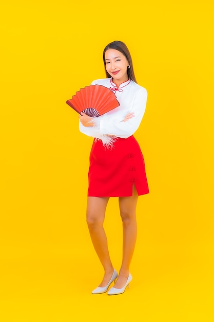 Portrait beautiful young asian woman with red envelopes letter on yellow