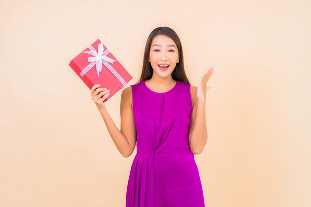 격리 된 색상 배경에 빨간색 선물 상자 초상화 아름 다운 젊은 아시아 여자