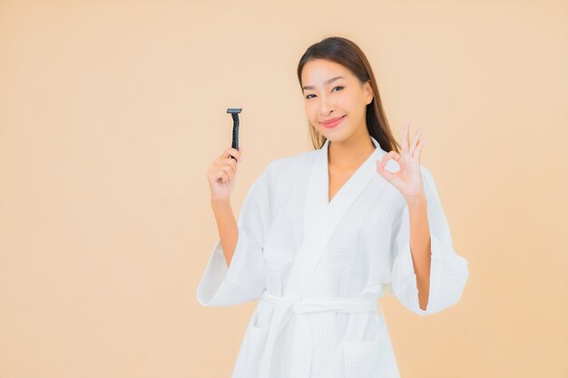 Portrait beautiful young asian woman with shaving on beige