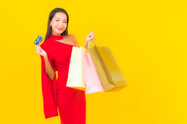 세로 쇼핑백과 신용 카드와 함께 아름 다운 젊은 아시아 여자