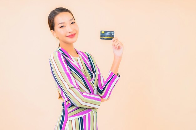 Portrait beautiful young asian woman with smart mobile phone and credit card on color