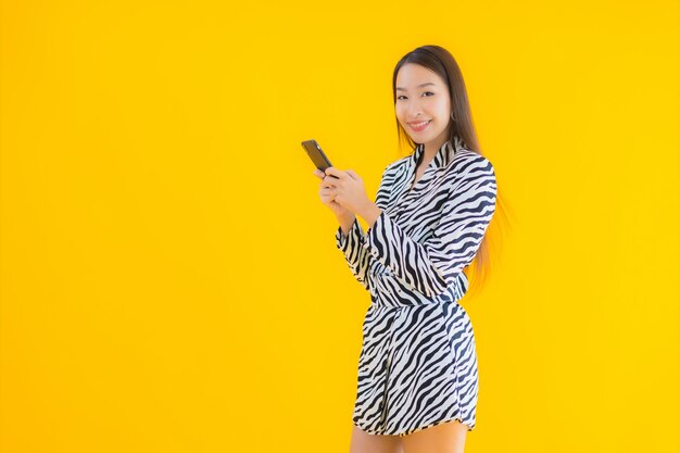 노란색에 스마트 휴대 전화 및 신용 카드와 초상화 아름 다운 젊은 아시아 여자