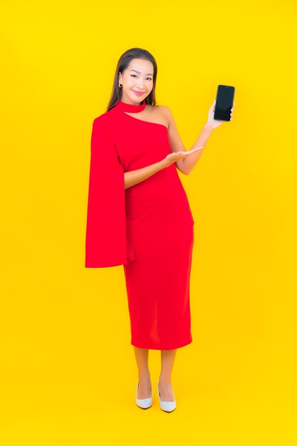 Женщина портрета красивая молодая азиатская с умным мобильным телефоном