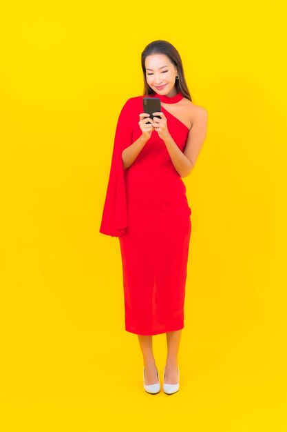 Женщина портрета красивая молодая азиатская с умным мобильным телефоном