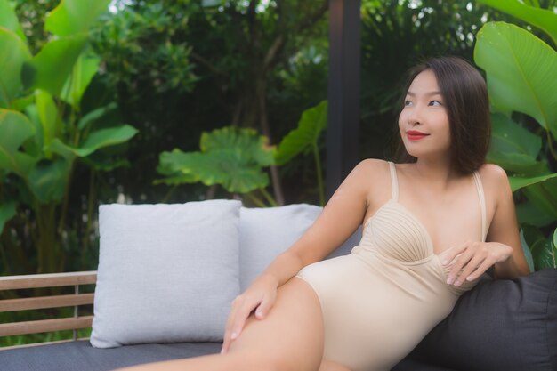肖像画美しい若いアジア女性の幸せな笑顔はリゾートの屋外スイミングプールをリラックスします。