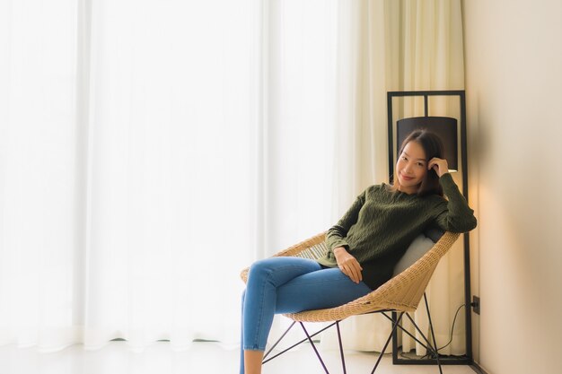 Portrait beautiful young asian women happy smile relax sitting on sofa chair