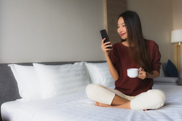 커피와 휴대 전화 세로 아름다운 젊은 아시아 여성 행복한 미소