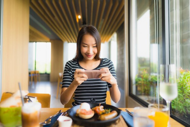 肖像画の美しい若いアジア女性はレストランやコーヒーショップカフェで幸せな笑顔