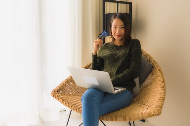 온라인 쇼핑을 위해 신용 카드로 컴퓨터 노트북을 사용하는 세로 아름다운 젊은 아시아 여성