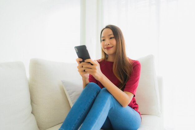 Portrait beautiful young asian women using mobile or smart phone on sofa