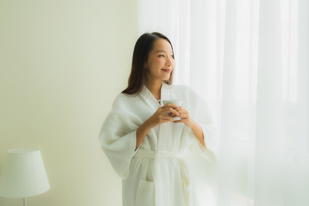 Portrait beautiful young asian women with coffee cup in bedroom