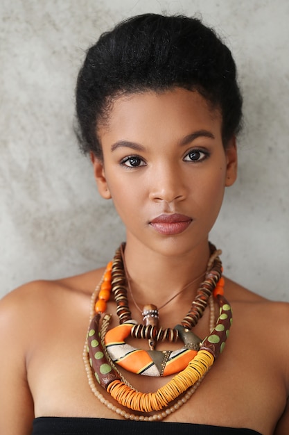 Foto gratuita ritratto di bella giovane donna di colore con la collana africana tradizionale