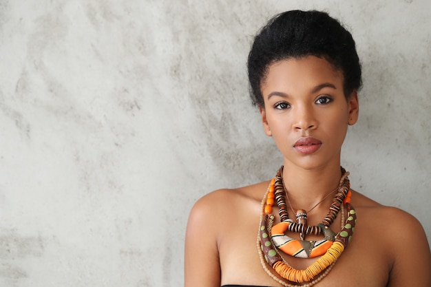 Free photo portrait of beautiful young black woman with traditional african necklace