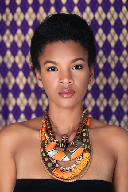 Portrait of beautiful young black woman with traditional African necklace