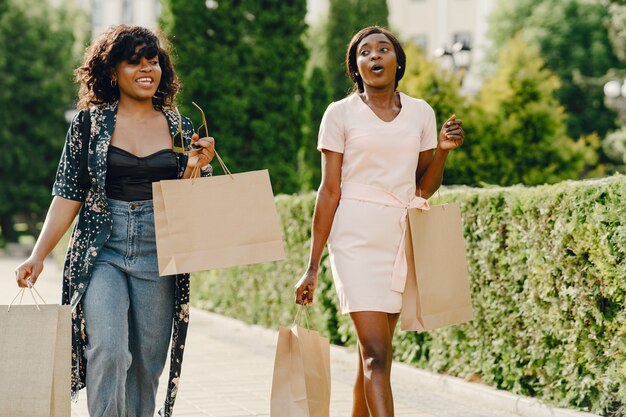 Portrait of beautiful young black women with shopping bags