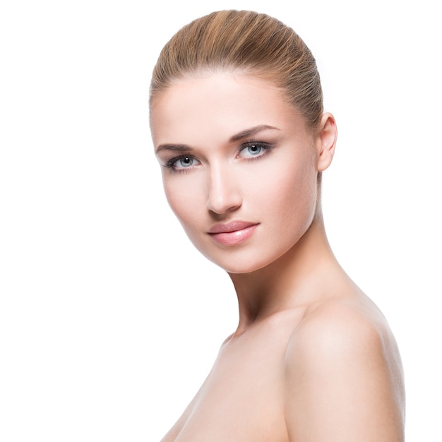 Portrait of beautiful young blonde woman with clean skin  - on white wall.