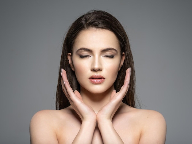 Portrait of beautiful young brunette woman with clean face. Calm face. Pretty model with the closed eyes. Meditation