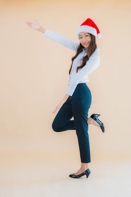 肖像画の美しい若いビジネスアジア女性はクリスマスの帽子を着用します。