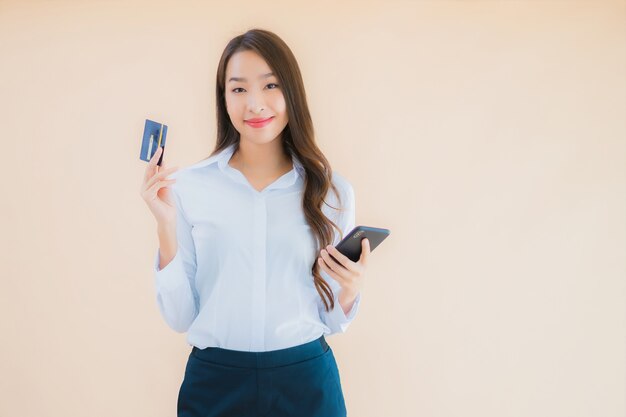 전화 및 신용 카드와 세로 아름 다운 젊은 비즈니스 아시아 여자