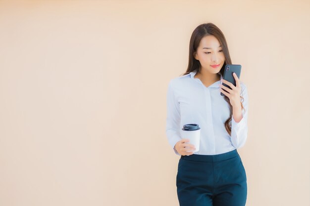 Portrait beautiful young business asian woman with smart mobile phone and coffee cup